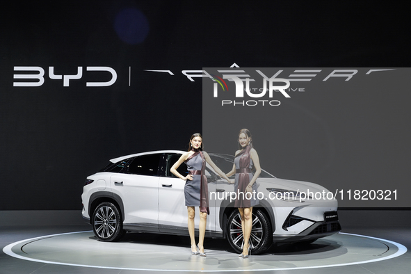 A model stands next to an electric BYD SEALION 7 at the Thailand International Motor Expo 2024 at IMPACT exhibition center in Bangkok, Thail...