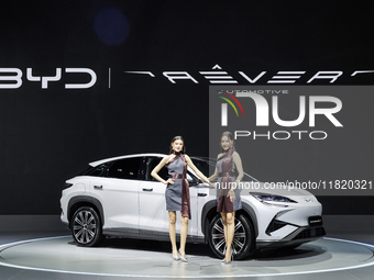 A model stands next to an electric BYD SEALION 7 at the Thailand International Motor Expo 2024 at IMPACT exhibition center in Bangkok, Thail...