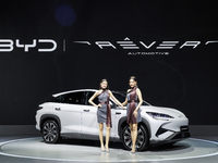 A model stands next to an electric BYD SEALION 7 at the Thailand International Motor Expo 2024 at IMPACT exhibition center in Bangkok, Thail...