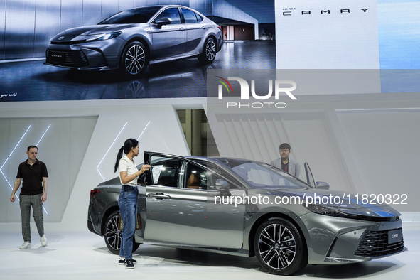 Visitors inspect a Toyota Camry car displayed at the Thailand International Motor Expo 2024 at the IMPACT Exhibition Center in Bangkok, Thai...