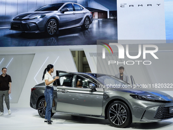 Visitors inspect a Toyota Camry car displayed at the Thailand International Motor Expo 2024 at the IMPACT Exhibition Center in Bangkok, Thai...