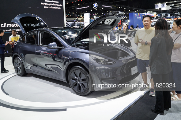 Visitors inspect a Tesla Model Y electric car displayed at the Thailand International Motor Expo 2024 at the IMPACT exhibition center in Ban...