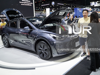 Visitors inspect a Tesla Model Y electric car displayed at the Thailand International Motor Expo 2024 at the IMPACT exhibition center in Ban...