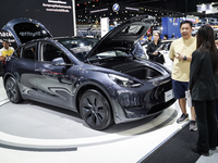 Visitors inspect a Tesla Model Y electric car displayed at the Thailand International Motor Expo 2024 at the IMPACT exhibition center in Ban...