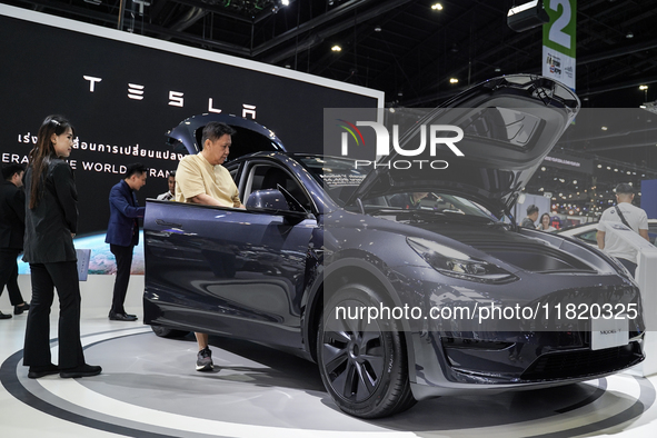 Visitors inspect a Tesla Model Y electric car displayed at the Thailand International Motor Expo 2024 at the IMPACT exhibition center in Ban...