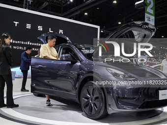 Visitors inspect a Tesla Model Y electric car displayed at the Thailand International Motor Expo 2024 at the IMPACT exhibition center in Ban...