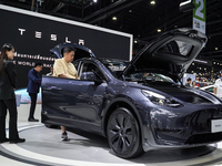 Visitors inspect a Tesla Model Y electric car displayed at the Thailand International Motor Expo 2024 at the IMPACT exhibition center in Ban...