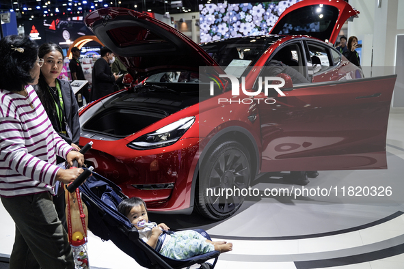 Visitors inspect a TESLA electric car displayed at the Thailand International Motor Expo 2024 at the IMPACT exhibition center in Bangkok, Th...