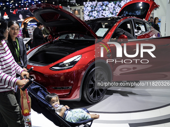 Visitors inspect a TESLA electric car displayed at the Thailand International Motor Expo 2024 at the IMPACT exhibition center in Bangkok, Th...