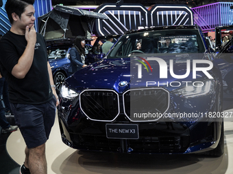 Visitors inspect a BMW X3 electric car displayed at the Thailand International Motor Expo 2024 at the IMPACT exhibition center in Bangkok, T...