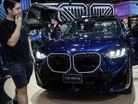 Visitors inspect a BMW X3 electric car displayed at the Thailand International Motor Expo 2024 at the IMPACT exhibition center in Bangkok, T...