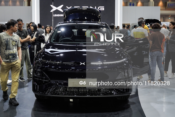 Visitors inspect an XPENG G6 electric car displayed at the Thailand International Motor Expo 2024 at the IMPACT exhibition center in Bangkok...