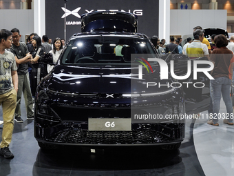 Visitors inspect an XPENG G6 electric car displayed at the Thailand International Motor Expo 2024 at the IMPACT exhibition center in Bangkok...