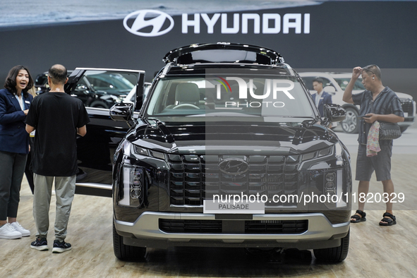 Visitors inspect a Hyundai Palisade electric car displayed at the Thailand International Motor Expo 2024 at the IMPACT Exhibition Center in...