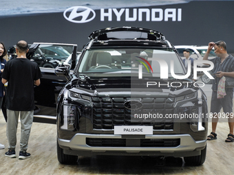 Visitors inspect a Hyundai Palisade electric car displayed at the Thailand International Motor Expo 2024 at the IMPACT Exhibition Center in...