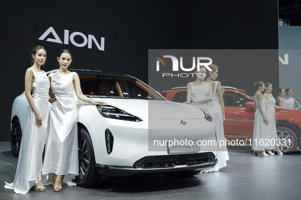 A model stands next to an electric AION HYPTEC HT at the Thailand International Motor Expo 2024 at the IMPACT exhibition center in Bangkok,...