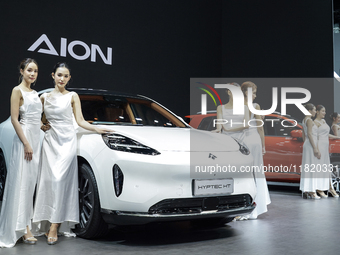 A model stands next to an electric AION HYPTEC HT at the Thailand International Motor Expo 2024 at the IMPACT exhibition center in Bangkok,...