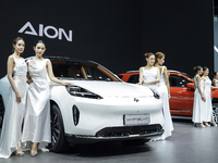 A model stands next to an electric AION HYPTEC HT at the Thailand International Motor Expo 2024 at the IMPACT exhibition center in Bangkok,...