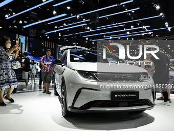 Visitors inspect a BYD DOLPHIN electric car displayed at the Thailand International Motor Expo 2024 at the IMPACT exhibition center in Bangk...