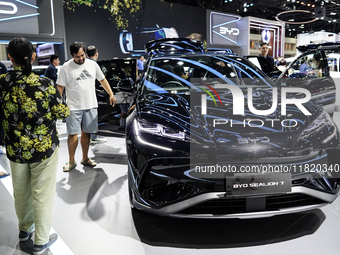 Visitors inspect a BYD SEALION 7 electric car displayed at the Thailand International Motor Expo 2024 at IMPACT exhibition center in Bangkok...