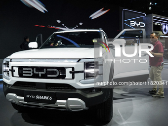 Visitors inspect a BYD SHARK 6 electric car displayed at the Thailand International Motor Expo 2024 at the IMPACT exhibition center in Bangk...