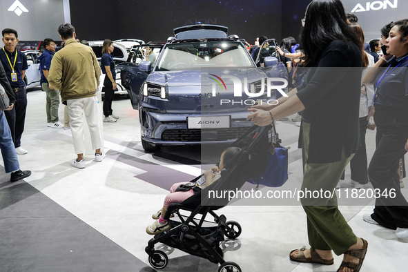 Visitors inspect an AION V electric car displayed at the Thailand International Motor Expo 2024 at the IMPACT exhibition center in Bangkok,...