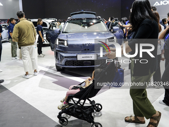 Visitors inspect an AION V electric car displayed at the Thailand International Motor Expo 2024 at the IMPACT exhibition center in Bangkok,...