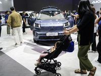 Visitors inspect an AION V electric car displayed at the Thailand International Motor Expo 2024 at the IMPACT exhibition center in Bangkok,...