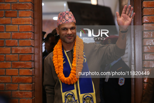 Former Indian opener Shikhar Dhawan waves at the media as he walks out of the VIP terminal of Tribhuvan International Airport in Kathmandu,...