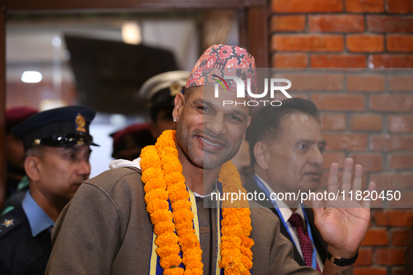 Former Indian opener Shikhar Dhawan waves at the media as he walks out of the VIP terminal of Tribhuvan International Airport in Kathmandu,...