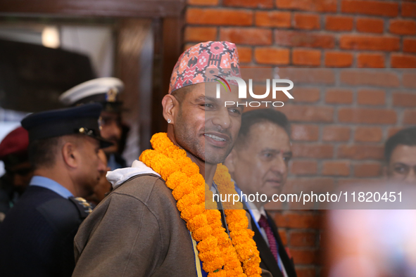 Former Indian opener Shikhar Dhawan waves at the media as he walks out of the VIP terminal of Tribhuvan International Airport in Kathmandu,...