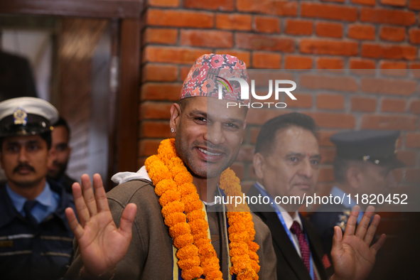 Former Indian opener Shikhar Dhawan waves at the media as he walks out of the VIP terminal of Tribhuvan International Airport in Kathmandu,...