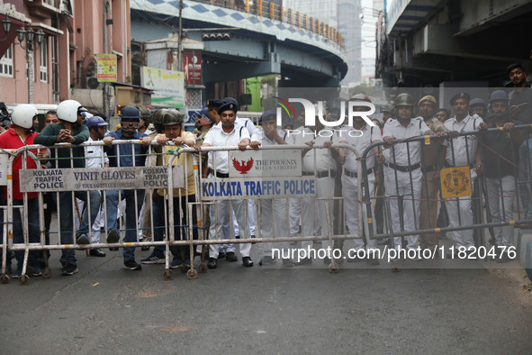 Police personnel block a road while supporters of the ISF (The Indian Secular Front) party shout slogans during a protest march towards the...