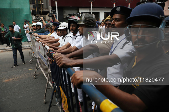 Police personnel block a road while supporters of the ISF (The Indian Secular Front) party shout slogans during a protest march towards the...