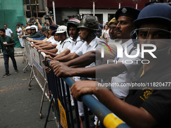 Police personnel block a road while supporters of the ISF (The Indian Secular Front) party shout slogans during a protest march towards the...