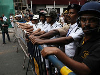 Police personnel block a road while supporters of the ISF (The Indian Secular Front) party shout slogans during a protest march towards the...