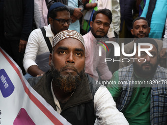 Police personnel block a road while supporters of the ISF (The Indian Secular Front) party shout slogans during a protest march towards the...