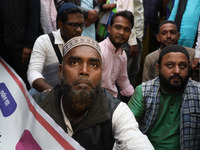 Police personnel block a road while supporters of the ISF (The Indian Secular Front) party shout slogans during a protest march towards the...