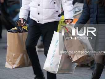 Shoppers carry Christmas shopping at the city center of Cologne, Germany, on November 29, 2024, during the Black Friday Sale. (