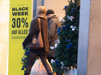 A general view shows shoppers walking out of a retail shop at the city center of Cologne, Germany, on November 29, 2024, during the Black Fr...