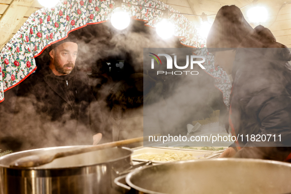 Sellers offer traditional Polish dumplings as visitors walk the alleys of Krakow's Christmas Market, one of the largest such markets in Euro...