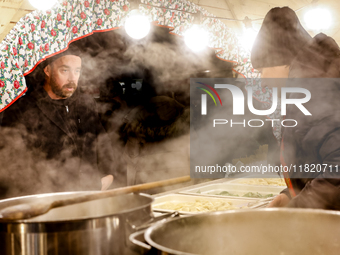 Sellers offer traditional Polish dumplings as visitors walk the alleys of Krakow's Christmas Market, one of the largest such markets in Euro...