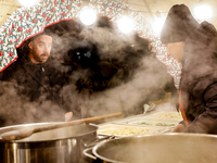 Sellers offer traditional Polish dumplings as visitors walk the alleys of Krakow's Christmas Market, one of the largest such markets in Euro...