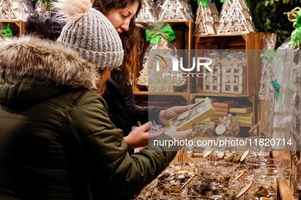 Visitors watch handmade sweets as they walk the alleys of Krakow's Christmas Market, one of the largest such markets in Europe as it opened...