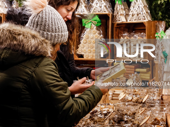 Visitors watch handmade sweets as they walk the alleys of Krakow's Christmas Market, one of the largest such markets in Europe as it opened...