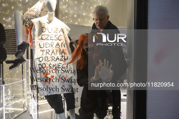 A member of the shop security tries to remove a climate activist as her hand is glued to the shop window. The mannequin bears a message that...