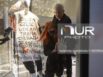 A member of the shop security tries to remove a climate activist as her hand is glued to the shop window. The mannequin bears a message that...