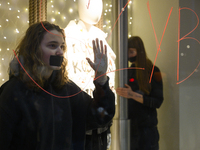 Climate activists with their hands glued to a shop window take part in a protest against fast fashion in Warsaw, Poland, on November 29, 202...