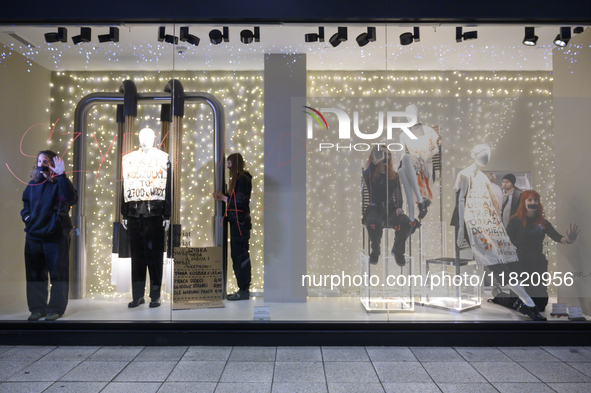 Climate activists with their hands glued to a shop window take part in a protest against fast fashion in Warsaw, Poland, on November 29, 202...