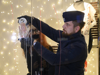 A police officer removes the glued hand of a climate activist during a protest against fast fashion in Warsaw, Poland, on November 29, 2024....